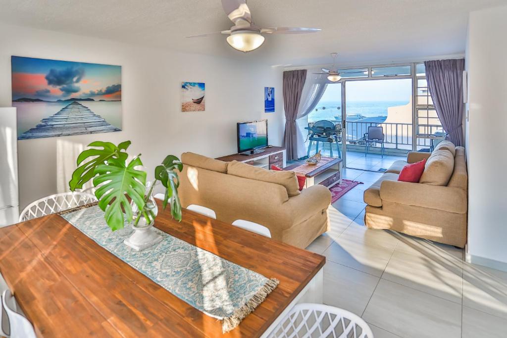a living room with a couch and a table at 302 Kenwyn on Sea- Luxury Beachfront Getaway in Ballito