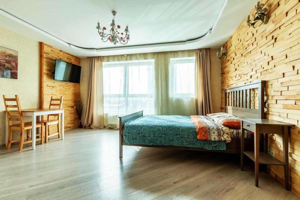 エカテリンブルクにあるЮмашева DreamHouse Апарт-отельのベッドルーム1室(ベッド1台、テーブル付)、ダイニングルームが備わります。