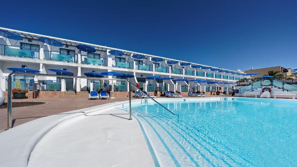 a large swimming pool in front of a hotel at Apartamentos Igramar MorroJable - Adults Only in Morro del Jable