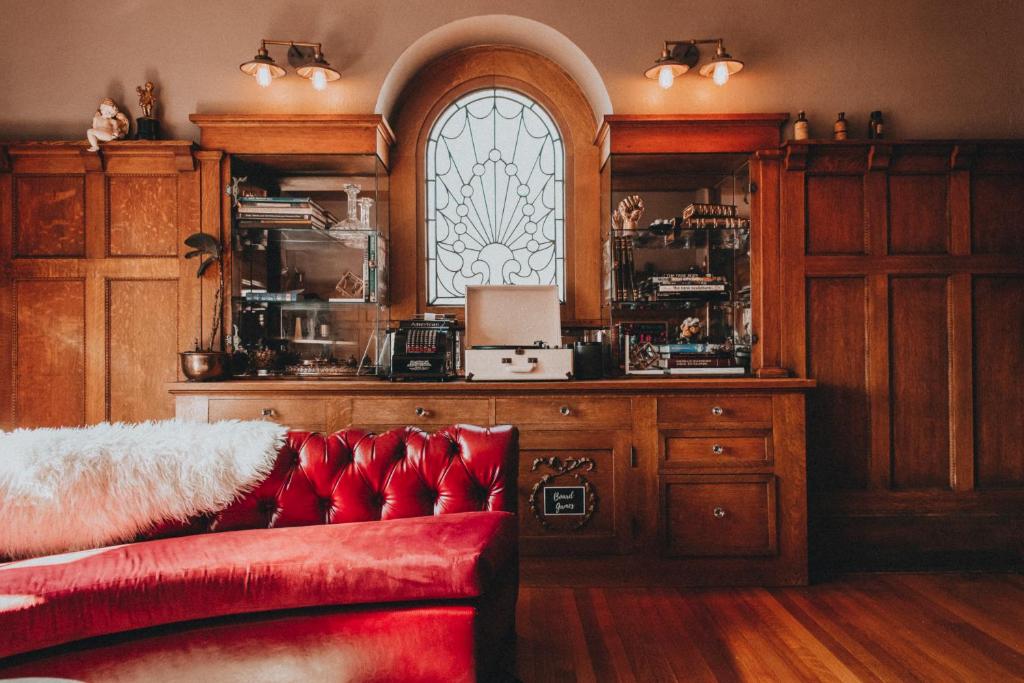 a room with a red couch and a window at Ember Hostel in Denver