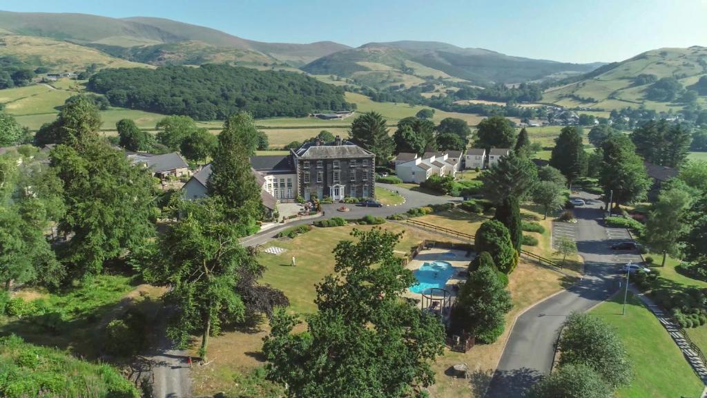 an aerial view of a mansion with mountains in the background at Macdonald Plas Talgarth Resort in Pennal