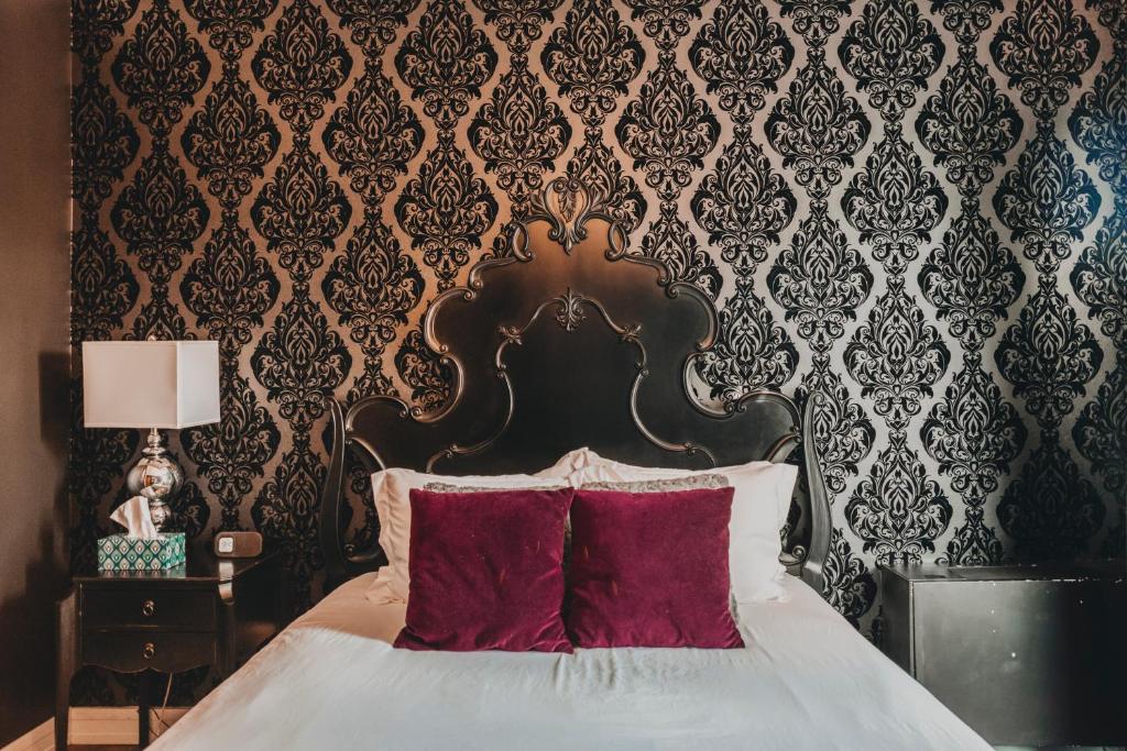 a bedroom with a large bed with red pillows at Ember Hostel in Denver