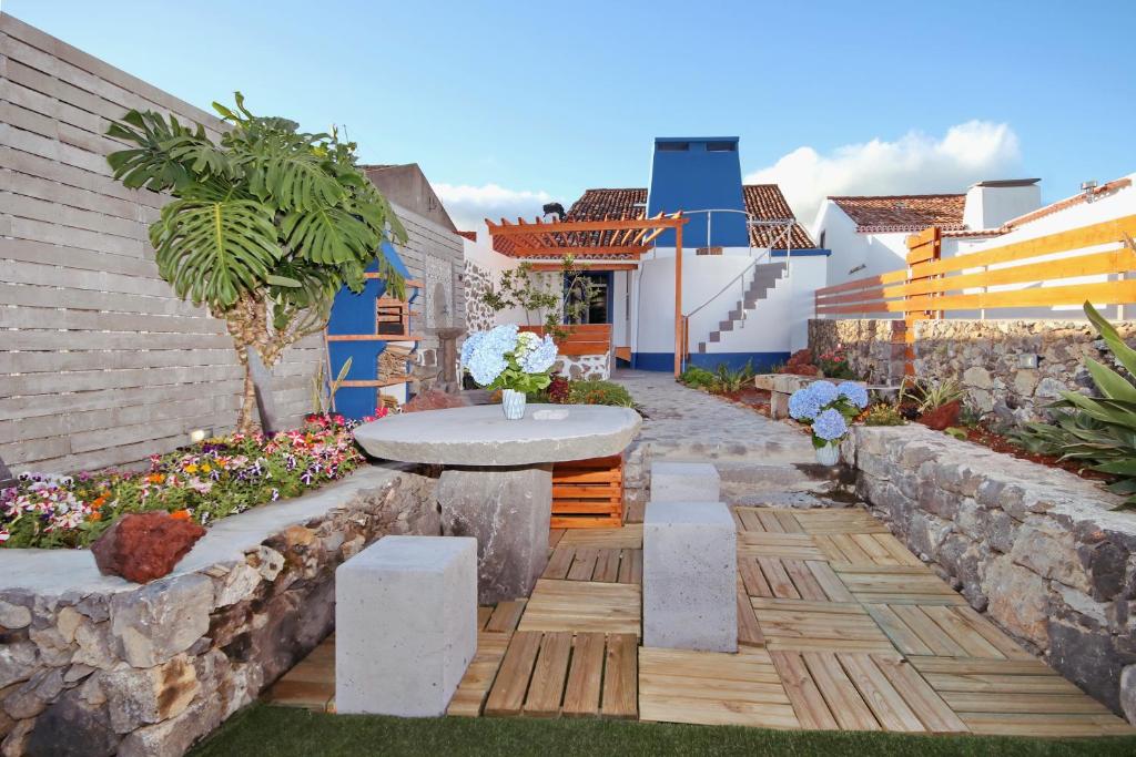 un jardín con una mesa y un banco en A Casinha Azul en Vila Franca do Campo