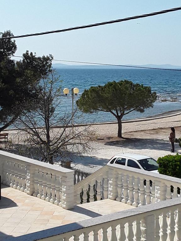 una recinzione bianca e un'auto bianca su una spiaggia di Apartmani Milka Zadar a Zara (Zadar)