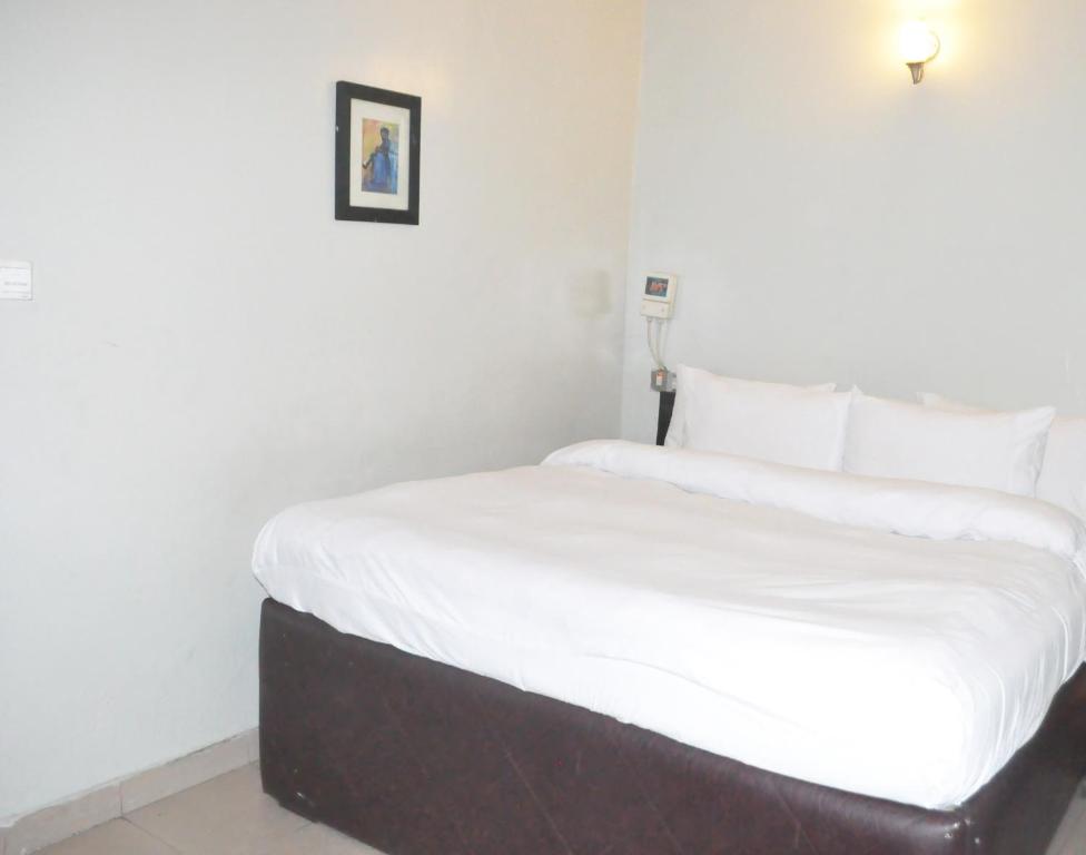 Postel nebo postele na pokoji v ubytování Triple Tee Hotel