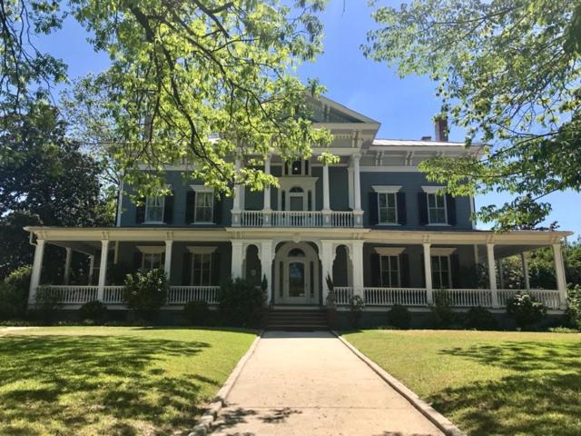 une grande maison bleue avec une terrasse couverte sur une pelouse dans l'établissement Elmwood 1820 Bed & Breakfast Inn, à Washington
