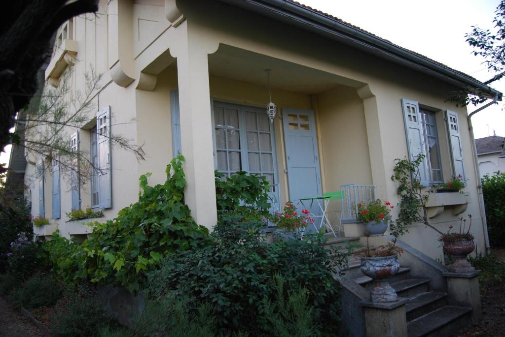 una casa blanca con macetas en las escaleras en Villa à 100 m de Tarbes sud, en Laloubère