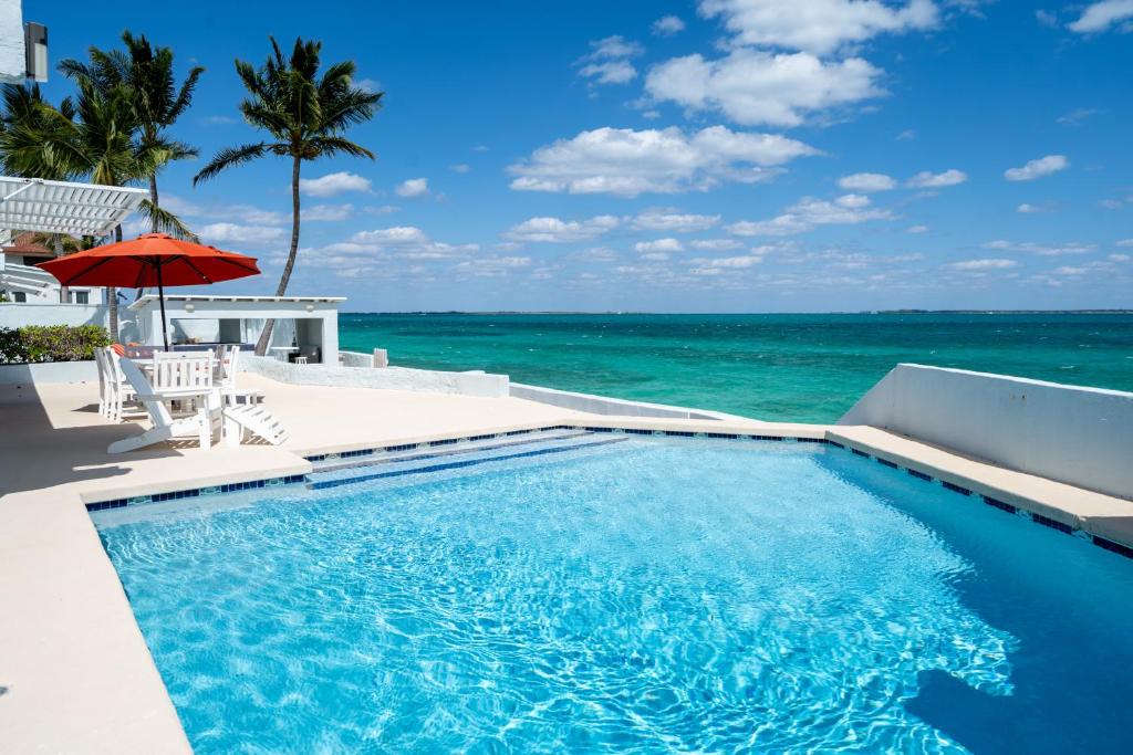 a swimming pool with the ocean in the background at Water's Edge Villa - Oceanfront with Private Pool in Nassau