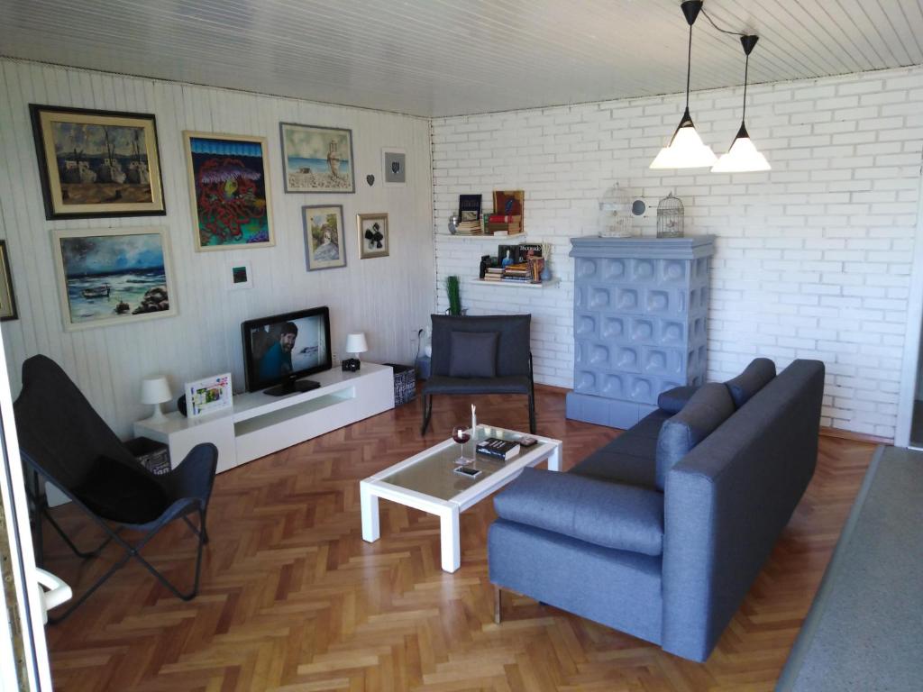 a living room with a blue couch and a tv at Apartman Mimi in Klenovica