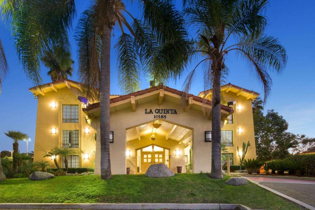 a building with palm trees in front of it at La Quinta Inn by Wyndham San Diego - Miramar in Sabre Springs