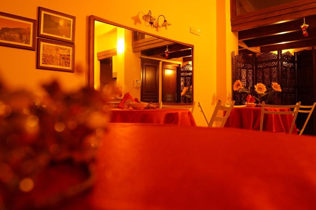 comedor con mesas rojas y espejo en B&B Il Fruscio, en Mormanno