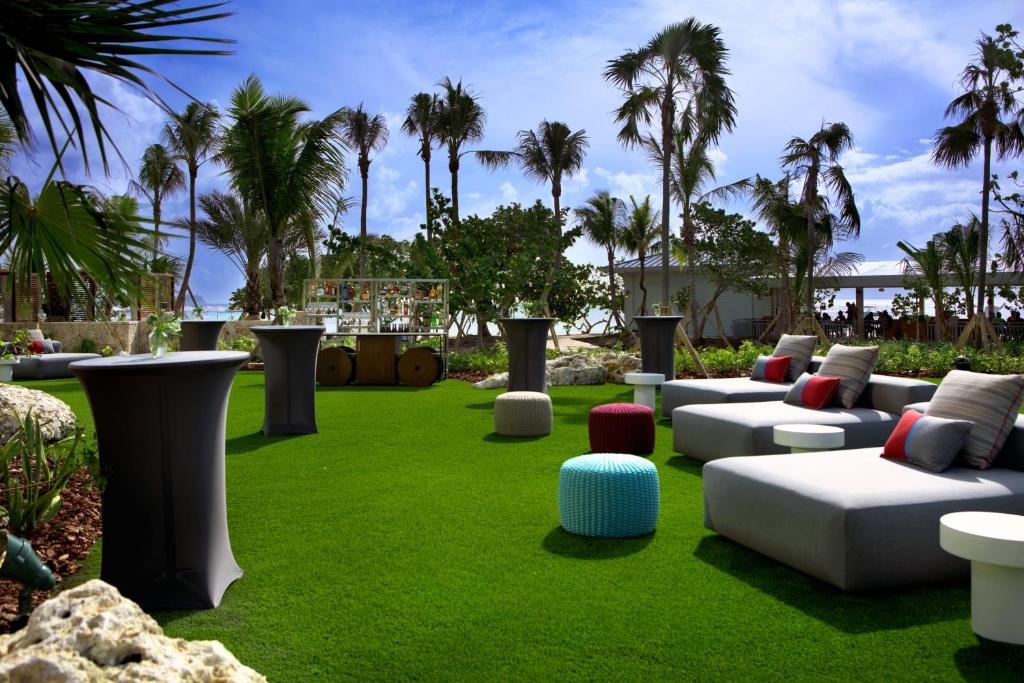 a garden with couches on a lawn with palm trees at Kimpton Seafire Resort + Spa by IHG in West Bay