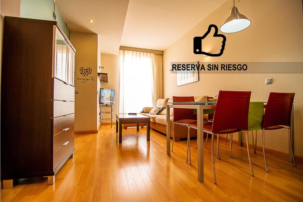 sala de estar con mesa, sillas y sofá en Dream Suites & Apartaments Almería en Almería