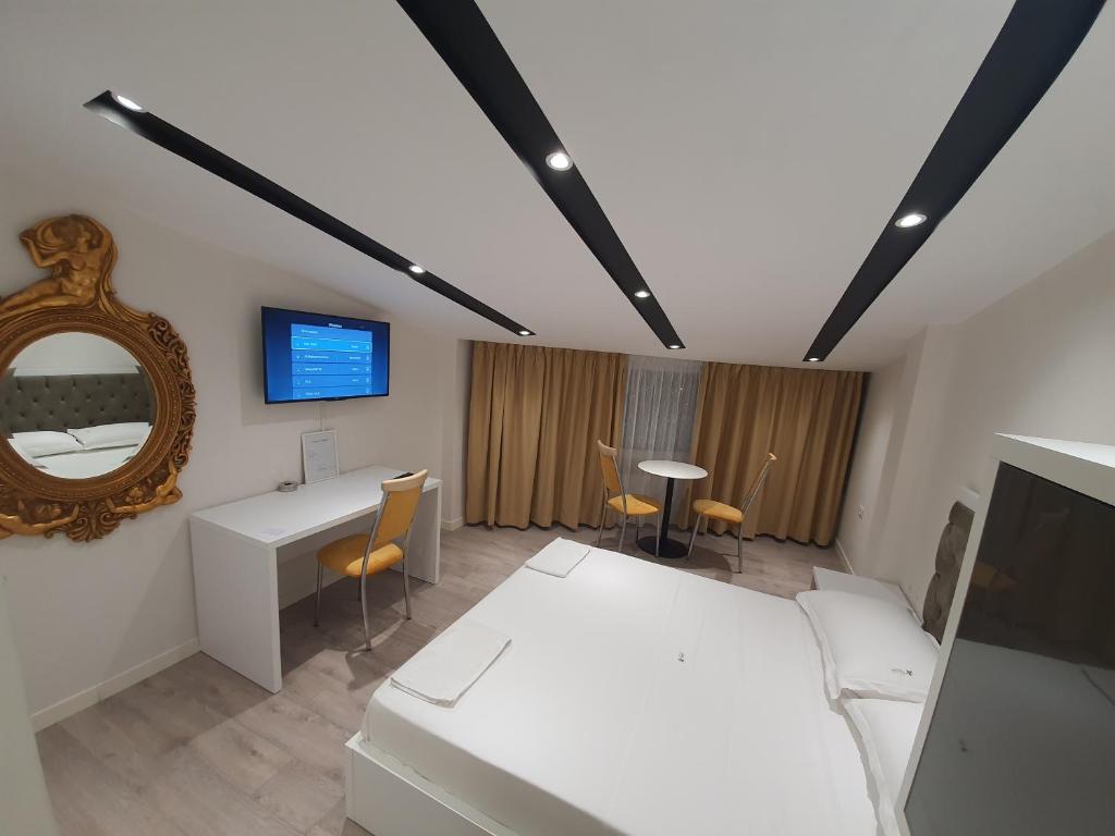 um quarto com uma cama, um espelho e uma secretária em Star Hotel em Tirana