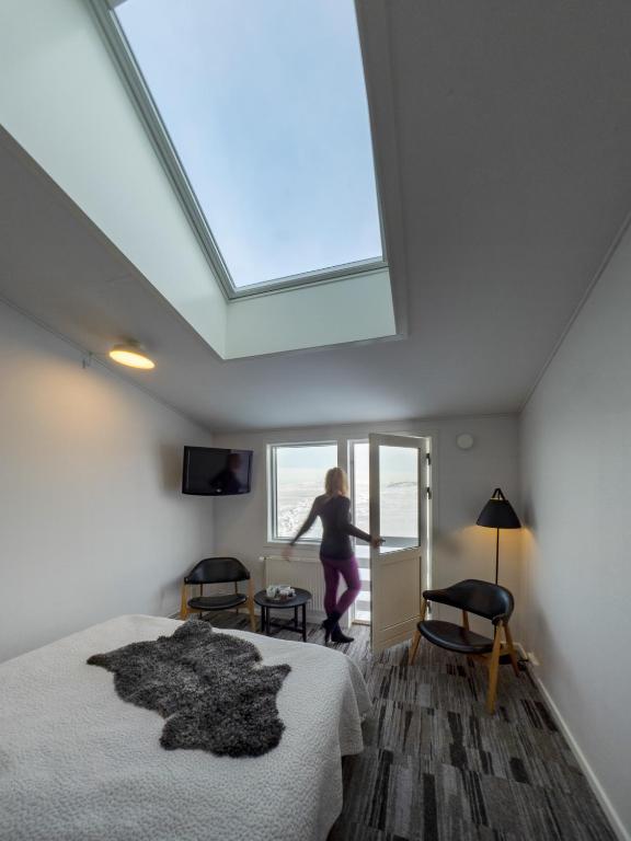 a woman jumping out of a window in a bedroom at Hotel Icefiord in Ilulissat