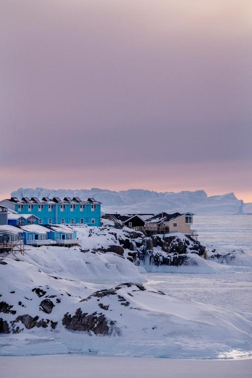 a blue building in the middle of a snow covered field at Hotel Icefiord in Ilulissat