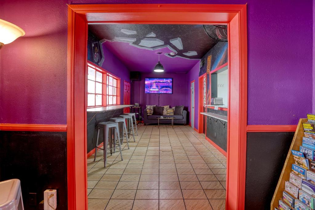 a corridor of a restaurant with purple walls at Sin City Hostel in Las Vegas