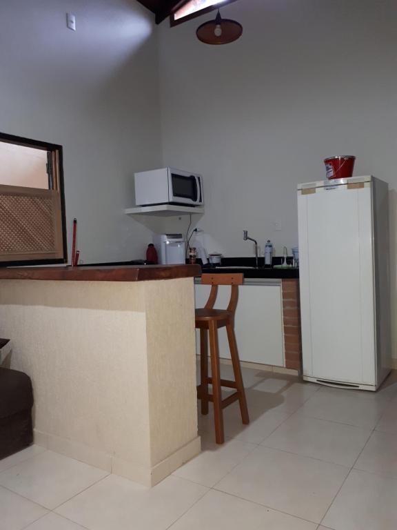 a kitchen with a counter and a refrigerator at Loft Pireneus 1 in Pirenópolis