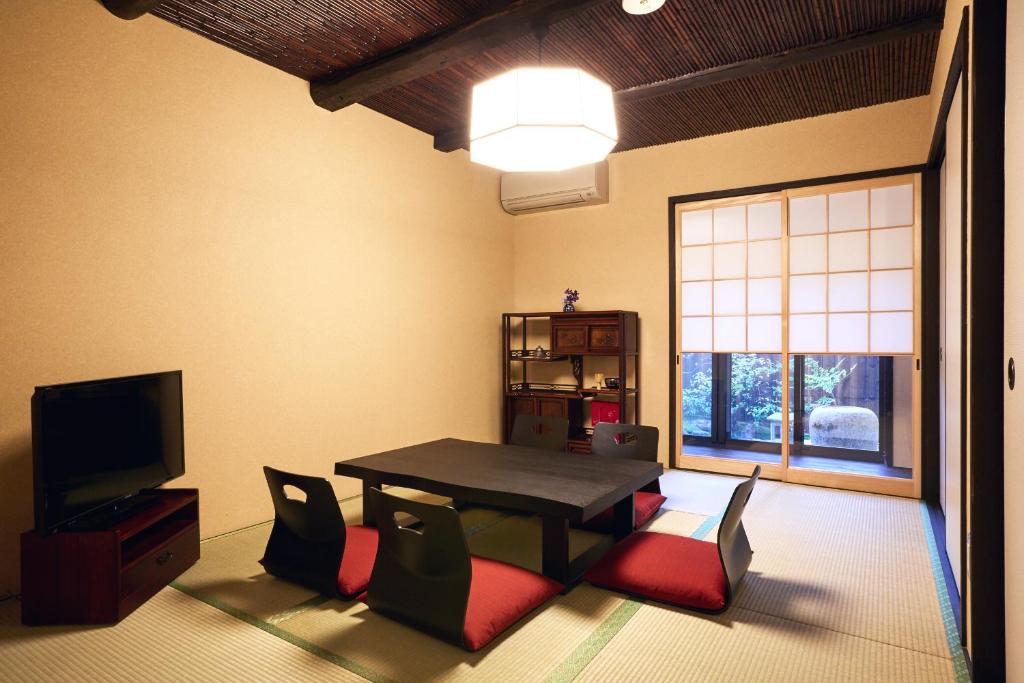 a living room with a table and chairs and a television at Rinn Kujofujinoki West in Kyoto
