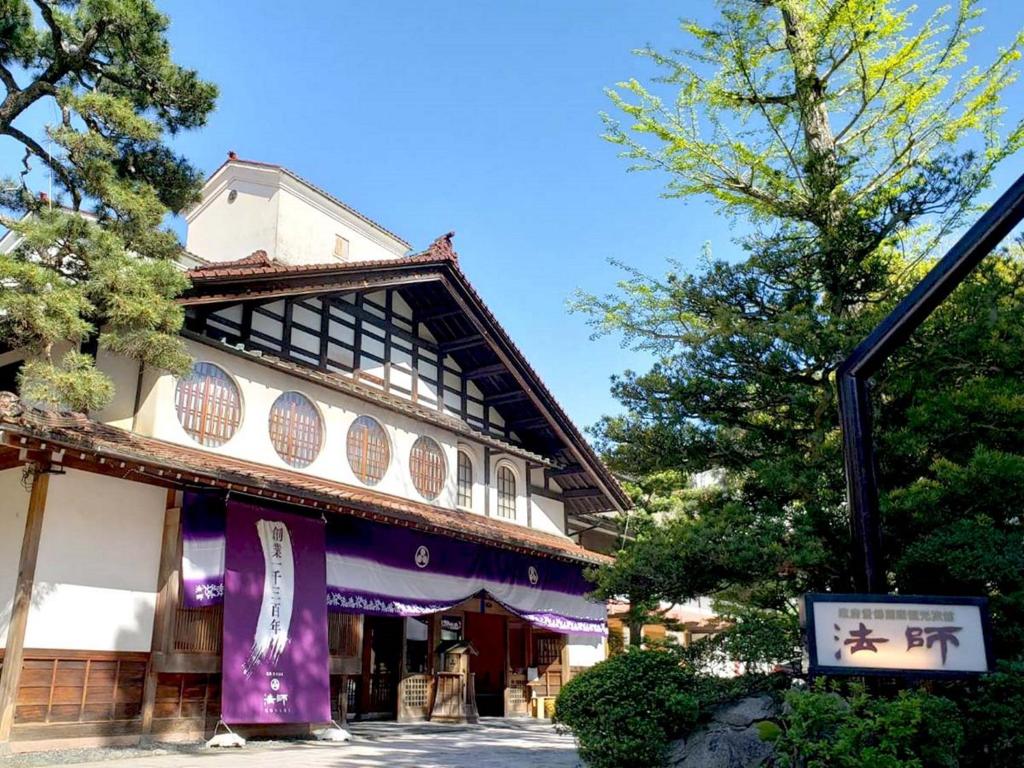 un edificio con una pancarta púrpura delante de él en Hoshi en Komatsu