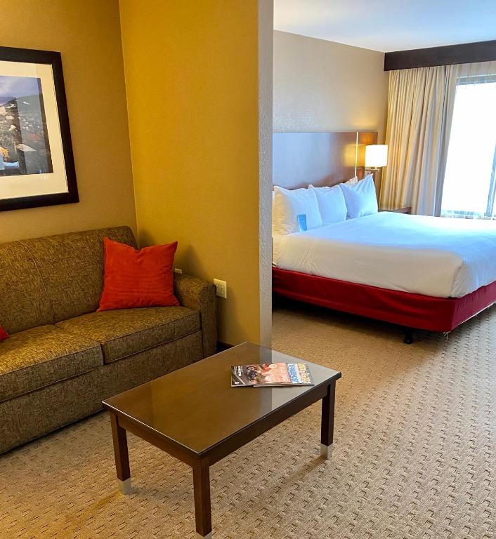 a hotel room with a bed and a couch and a table at Radisson Hotel Colorado Springs Airport in Colorado Springs