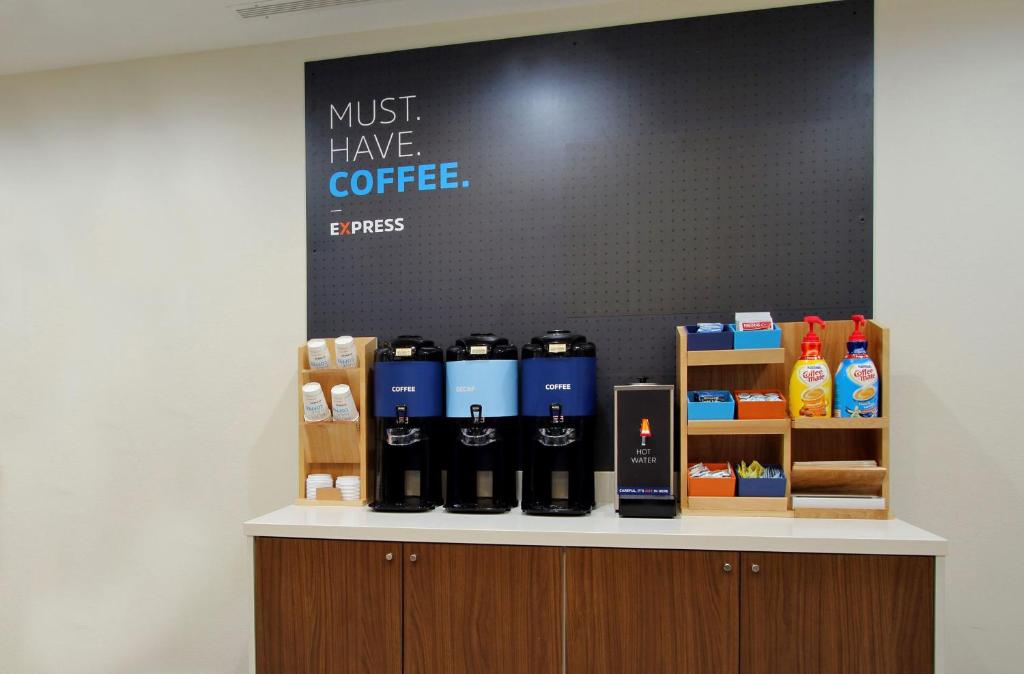 a counter with bottles of coffee on it at Holiday Inn Express Pekin - Peoria Area, an IHG Hotel in Pekin Heights