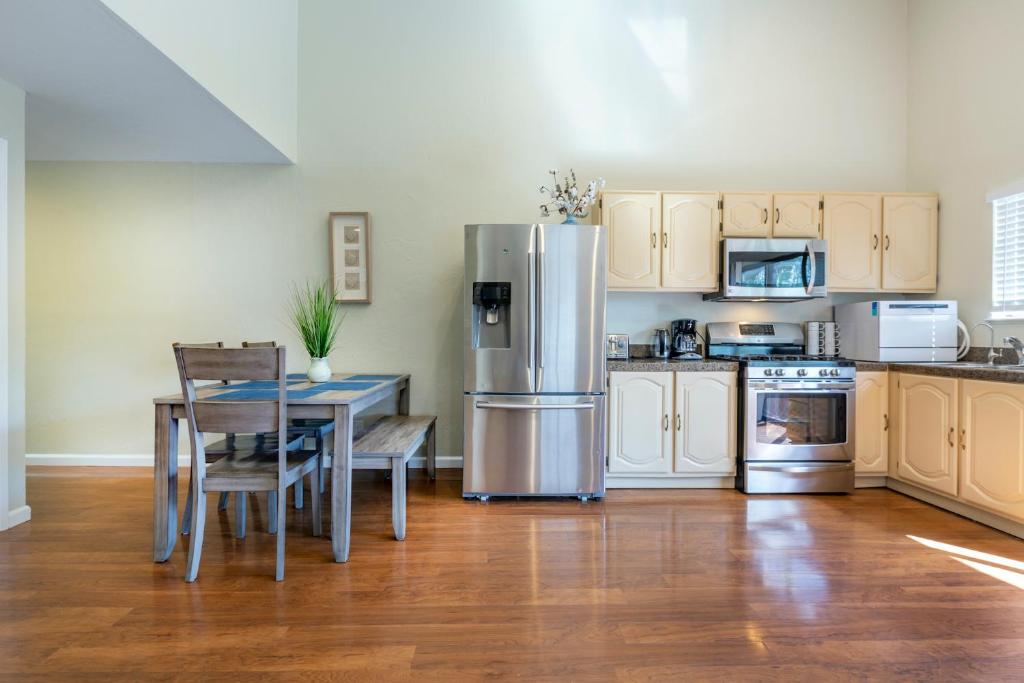 a kitchen with a table and a stainless steel refrigerator at @ Marbella Lane 3BR House in Downtown San Jose in San Jose