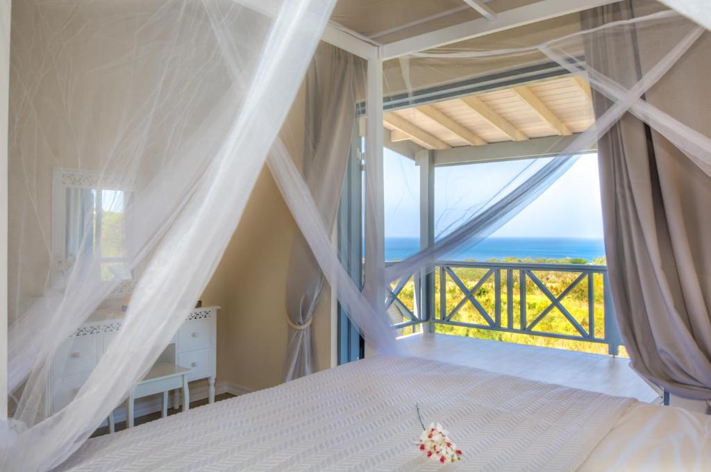 a bedroom with a bed with a view of the ocean at West Rock Villas in Saint James