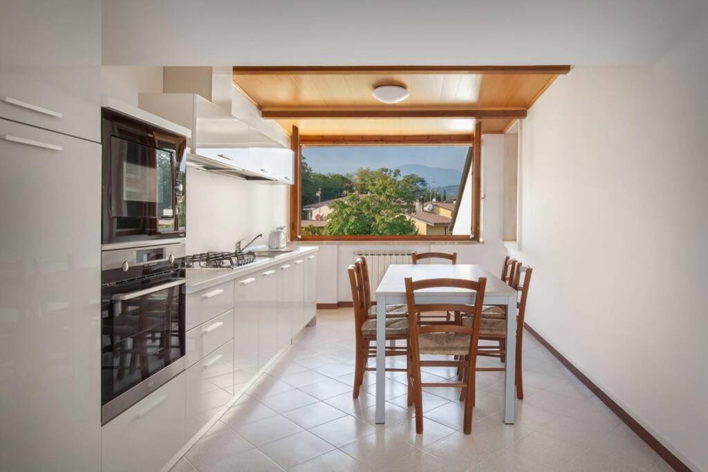 een keuken met een tafel en stoelen en een raam bij Casa San Floriano-In Valpolicella in San Pietro in Cariano