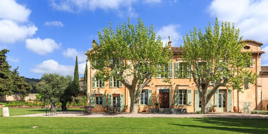 ein großes Haus mit zwei Bäumen davor in der Unterkunft Château des Demoiselles in La Motte