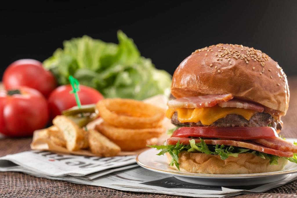 a hamburger on a plate with french fries and tomatoes at Nagoya Marriott Associa Hotel in Nagoya