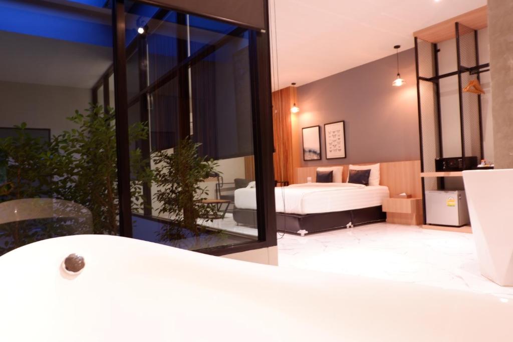 a bedroom with a bed and a large window at Chill D Resort Buriram in Buriram