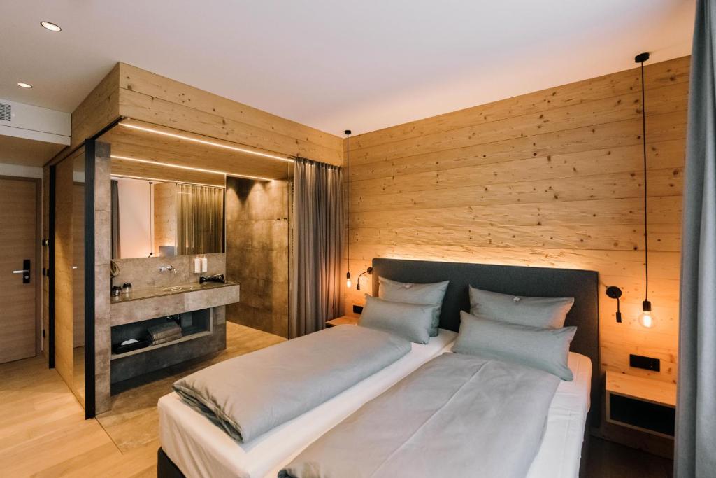 ヒルポルトシュタインにあるHotel Johannsの木製の壁のベッドルーム1室(大型ベッド1台付)