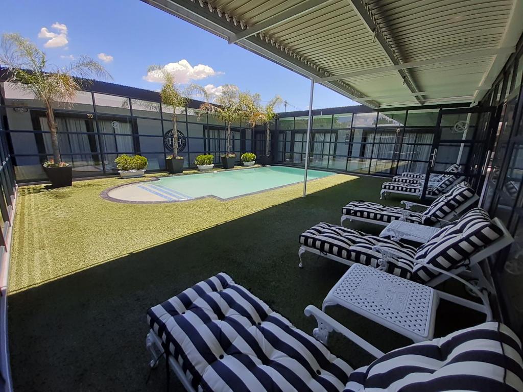 um pátio com espreguiçadeiras e uma piscina em Halfway House Hotel em Kimberley