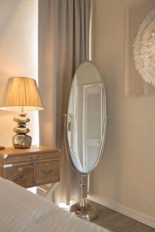 a mirror sitting on a table next to a bed at West Rock Villas in Saint James