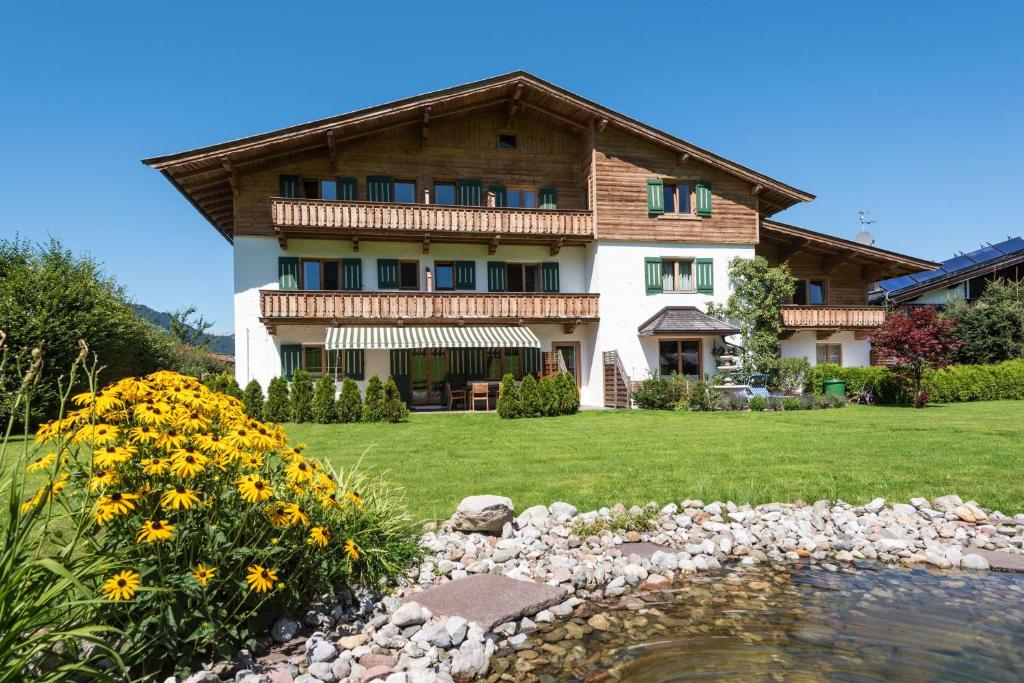 ein Haus mit einem Teich davor in der Unterkunft Apartments Foidl in Kitzbühel