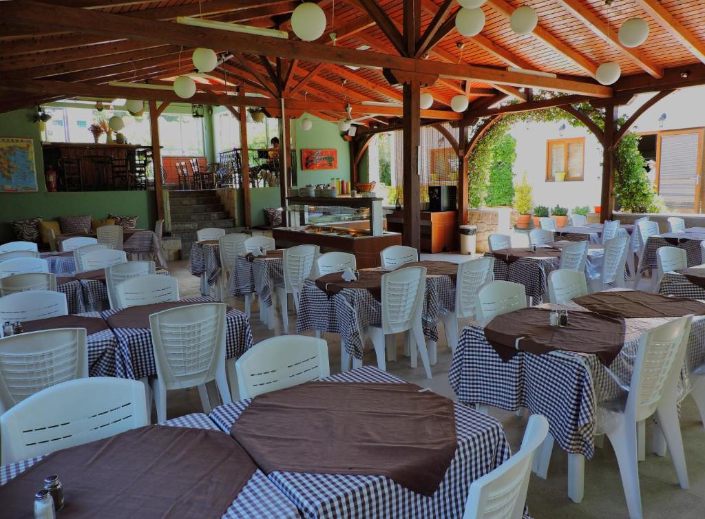 a dining room with tables and white chairs at Julia Hotel in Fourka
