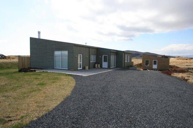a large building in the middle of a field at Golden Circle Luxury Villa in Selfoss