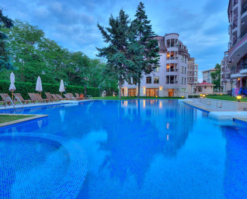 een groot zwembad voor een gebouw bij Purple Star Apartments in Sveti Konstantin