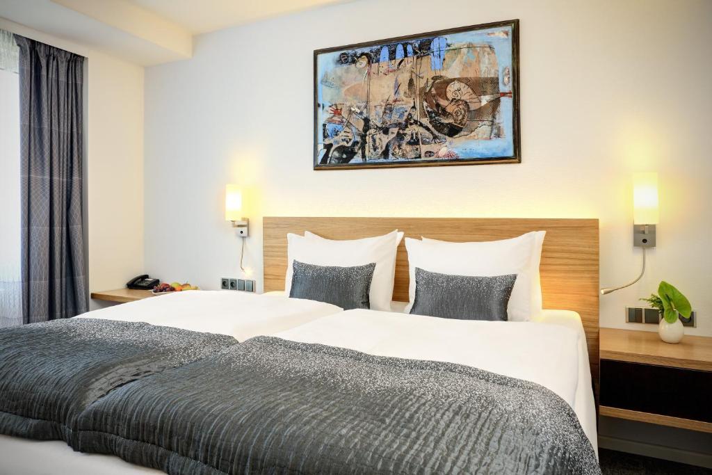 ein Hotelzimmer mit 2 Betten und einem Gemälde an der Wand in der Unterkunft Hotel Duo in Prag