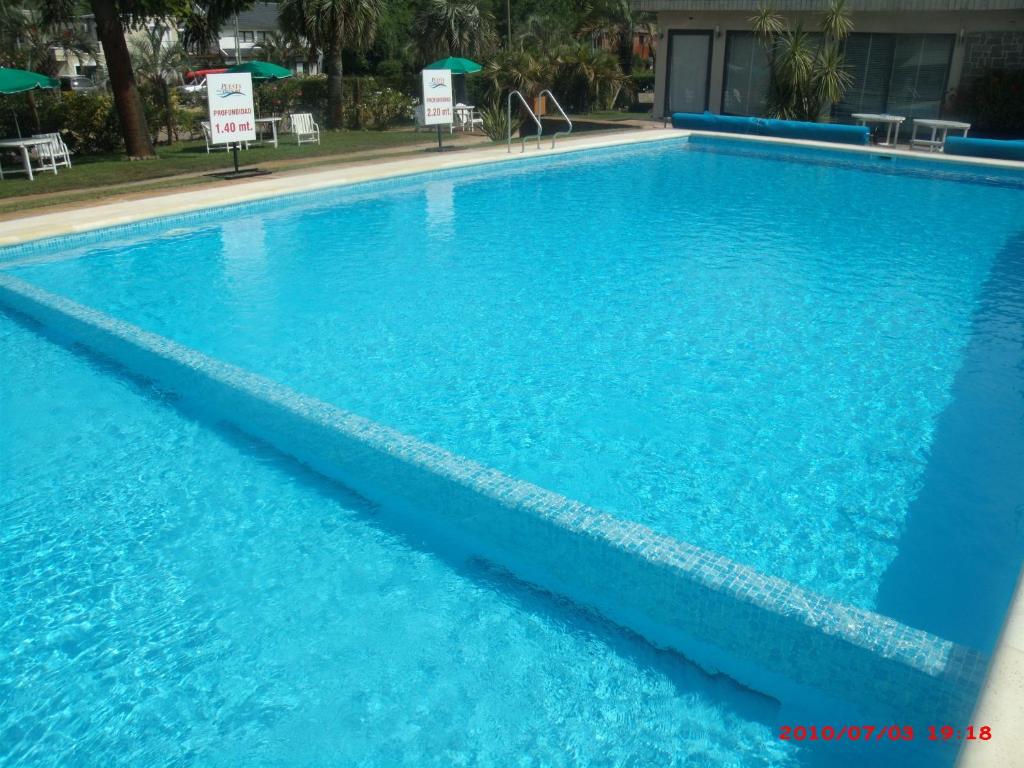 a large swimming pool with blue water at Hotel Puesta del Sol in Punta del Este