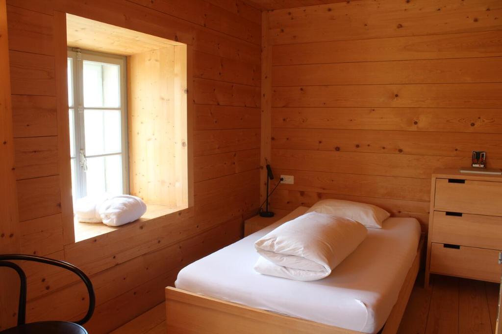 a bedroom with a bed in a wooden room at Ospizio San Gottardo in Airolo