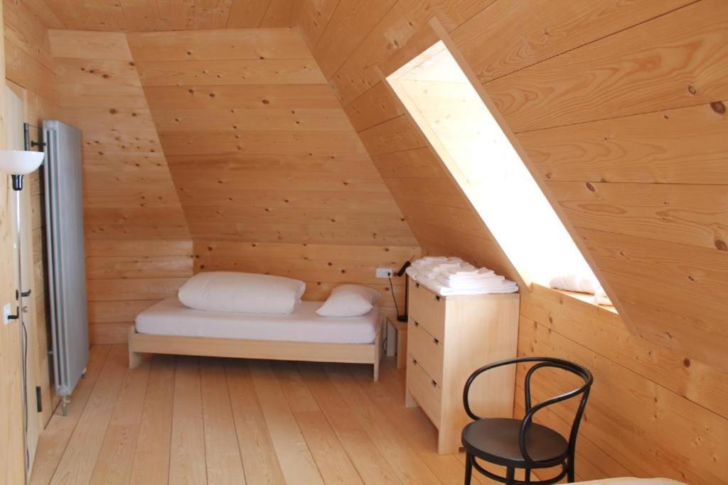a room with a bed and a chair in a attic at Ospizio San Gottardo in Airolo