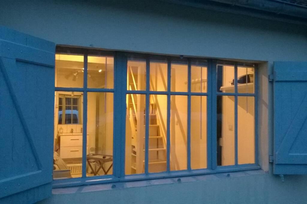 L'Atelier à 100 m de Tarbes sud في Laloubère: نافذة على مبنى مع انعكاس للسيارة