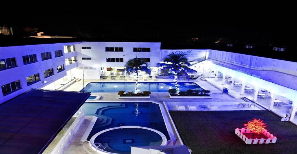 an overhead view of a building with a swimming pool at night at Hotel Mall Santana Del Río in La Dorada