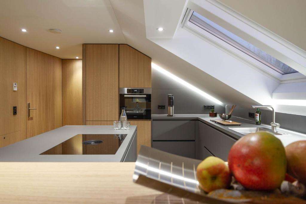 Toploft Serviced Apartments في كرايلسهايم: مطبخ مع تفاح على طاولة في مطبخ