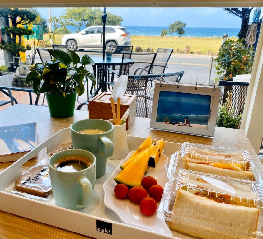 a tray of food on a table with a laptop and coffee at LoveSea 126 Beach Inn in Kenting