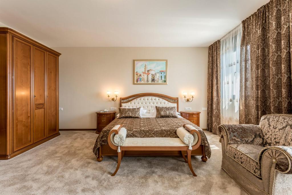 a bedroom with a bed and a couch and a chair at Hotel Cvita in Split