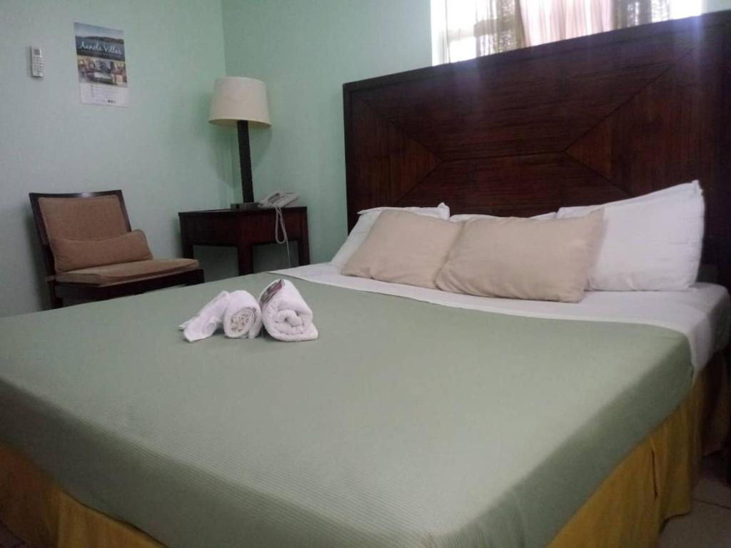 Una habitación de hotel con una cama con toallas. en Aanola Villas 6a Tranquil Privy Bedroom, en Charlotte