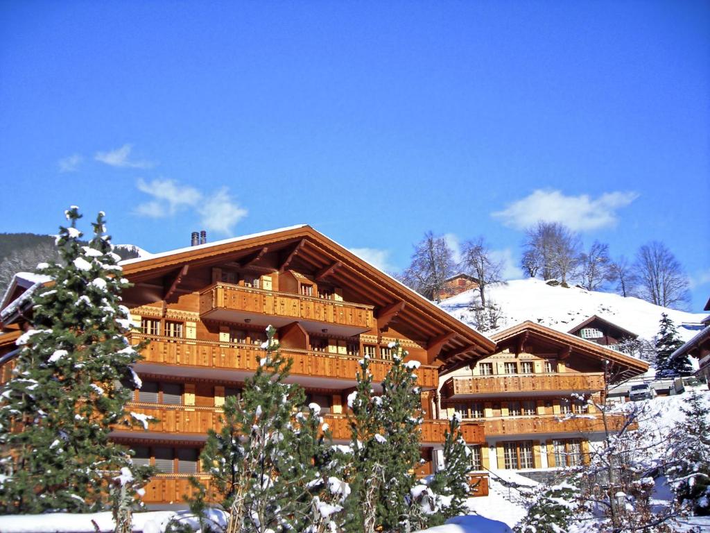 a large log building with snow on the ground at Apartment Chalet Smaragd-3 by Interhome in Grindelwald